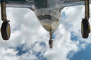 Aircraft fighter on take-off with chassis released from the bottom view against a blue cloudy sky close-up. photo
