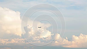 Aircraft flying through the sky with clouds at sunset