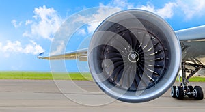 Aircraft jet engine close-up, airplane wing and chassis of landing gear wheel parked at the airport on a sky clouds background, pa