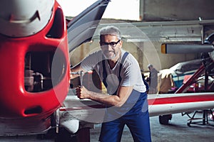 Aircraft maintenance mechanic inspects plane engine