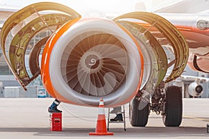 Aircraft Maintenance Mechanics Inspecting and Working on Airplane Jet Engine on Apron.