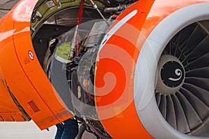 Aircraft Maintenance Mechanics Inspecting and Working on Airplane Jet Engine on Apron.