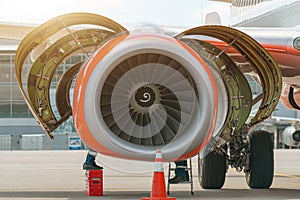 Aircraft Maintenance Mechanics Inspecting and Working on Airplane Jet Engine on Apron.