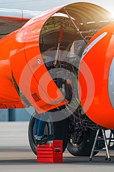 Aircraft Maintenance Mechanics Inspecting and Working on Airplane Jet Engine on Apron.