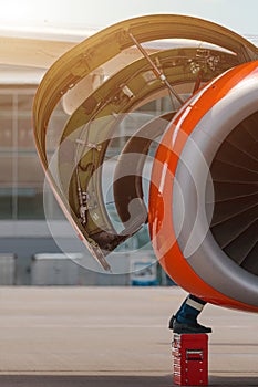 Aircraft Maintenance Mechanics Inspecting and Working on Airplane Jet Engine on Apron.