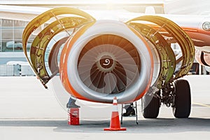 Aircraft Maintenance Mechanics Inspecting and Working on Airplane Jet Engine on Apron.