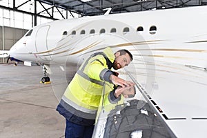 Aircraft mechanic inspects and checks the technology of a jet in photo
