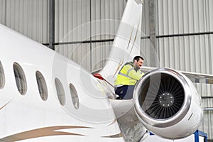 Aircraft mechanic inspects and checks the technology of a jet in a hangar at the airport photo