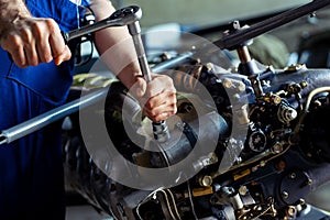 Aircraft mechanic repairing jet engine