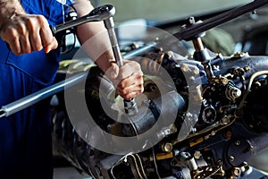 Aircraft mechanic repairing jet engine photo