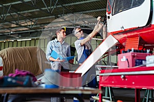 Aircraft mechanics in the hangar. Coworkers repairing an aircraft