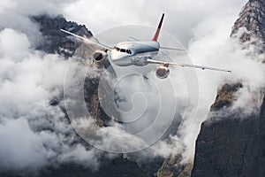 Aircraft, mountains in overcast sky. Airplane