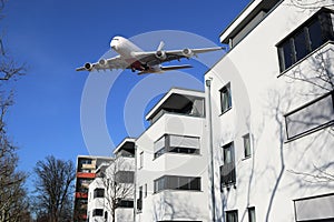 Aircraft noise and commercial wide-body aircraft over houses photo