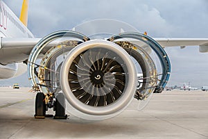 Aircraft parked with open hatches for jet engine maintenance.