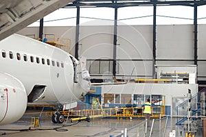 Aircraft. Passenger airplane under heavy maintenance in airport hangar indoors in the daytime