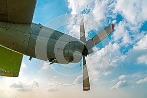 Aircraft Propeller and Spinner Engine on Airplane Wing Against Cloudy Blue Sky.