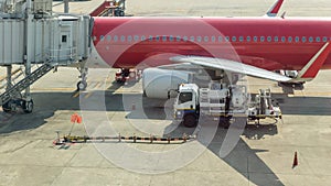 Aircraft refueling by high pressure fuel supply truck. Refueling operation of large widebody passenger aircraft standing on airpor photo