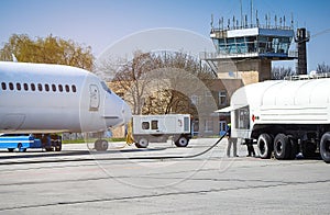 Aircraft refueling with a high pressure tanker. A passenger jet is being refueled from a supply truck. Airport Service