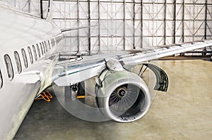 Aircraft service on repair diagnostics, inspection, view of the open engine hood and the fuselage of the airplane in the hangar.