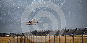 Airplane scenery:  take off from airport, mountain range in the alps. Travel by air, transportation photo