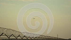 Aircraft taking off from Munich airport in Germany at sunset. Passenger airplane flying over airport runway in evening