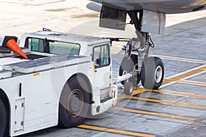 Airplane tow truck hooked up on the front landing gear.