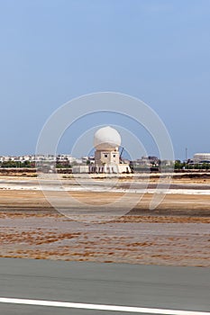Aircraft tracking radar tower at Muscat airport. Runway and tarmac at Muscat airport at day. Sultanate of Oman