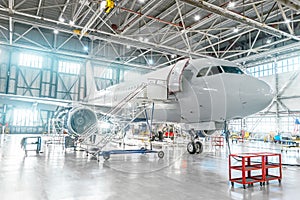 Aircraft under maintenance, checking mechanical systems for flight operations. Plane in the hangar