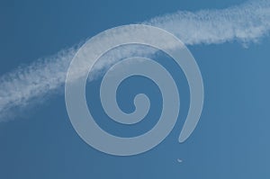 Aircraft vapour trail and moon in the sky of Gran Canaria.