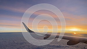 aircraft wing above clouds with sunset in background travel in plane with jet engines