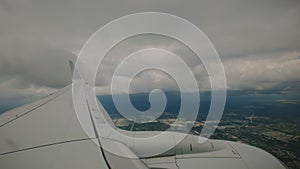 Aircraft Wing of flying in clouds airplane as seen by passenger through porthole windows. Wide view