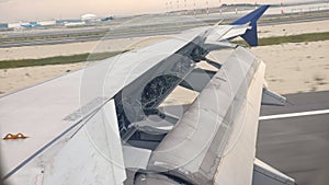 Aircraft wing outside board aileron lifting up for maneuvering speed while take off at the airport.