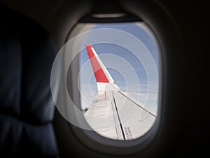 Aircraft winglet or wingtip from window seat. Blue sky Background. Static discharger on wingtip.