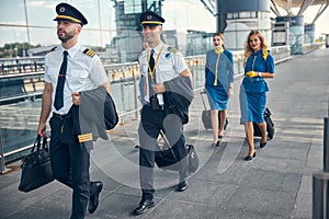 Aircrew with travel suitcases walking on the street