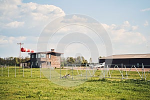Airdrome with green grass, buildings and aircraft
