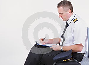 Airline captain pilot fills out the paperwork before the flight