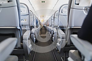 Airline passenger seats and aisle in airplane cabin photo