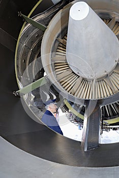 Airline pilot examining jet engine