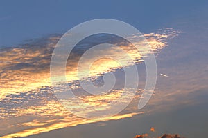 Airliner and clouds illuminated by the setting sun