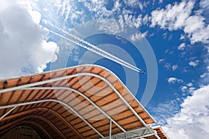 Airliner with Contrails Flying Above a Modern Airport