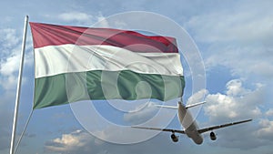 Airliner flying over waving flag of Hungary. 3D animation