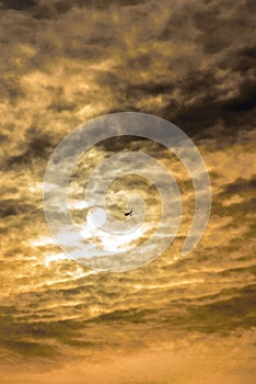 An airliner flying under the sun.