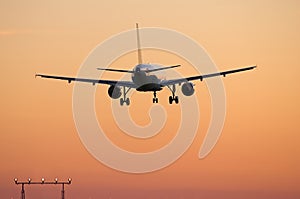 Airliner landing at sunset photo