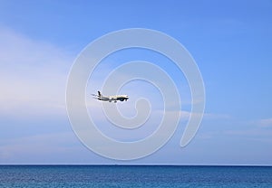 Airliner or Passenger plane Etihad Boeing 787-8 landing to airport next to the beach.