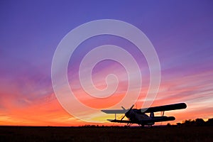 Airplane AN-2 on the airfield at sunset.