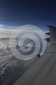 Airplane above the cloud on the sky background