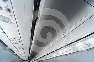 Airplane air conditioning control panel over seats. Stuffy air in aircraft cabin with people. New low-cost airline