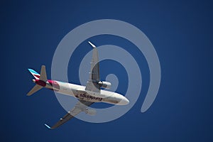 Airplane of the airline Eurowings from below against blue sky