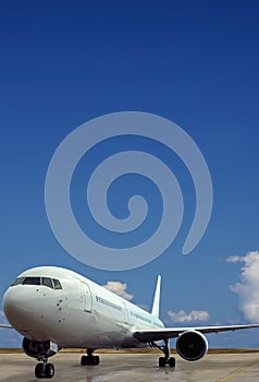 Airplane on airport. Blue sky background.