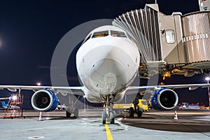 Airplane apron at the parking gangway at the airport at night.